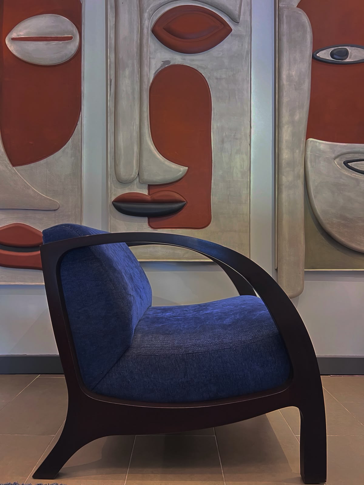 Poltrona orgánica de raulí tono 4 con tapiz azul, vista frontal en tres cuartos – El Ciprés